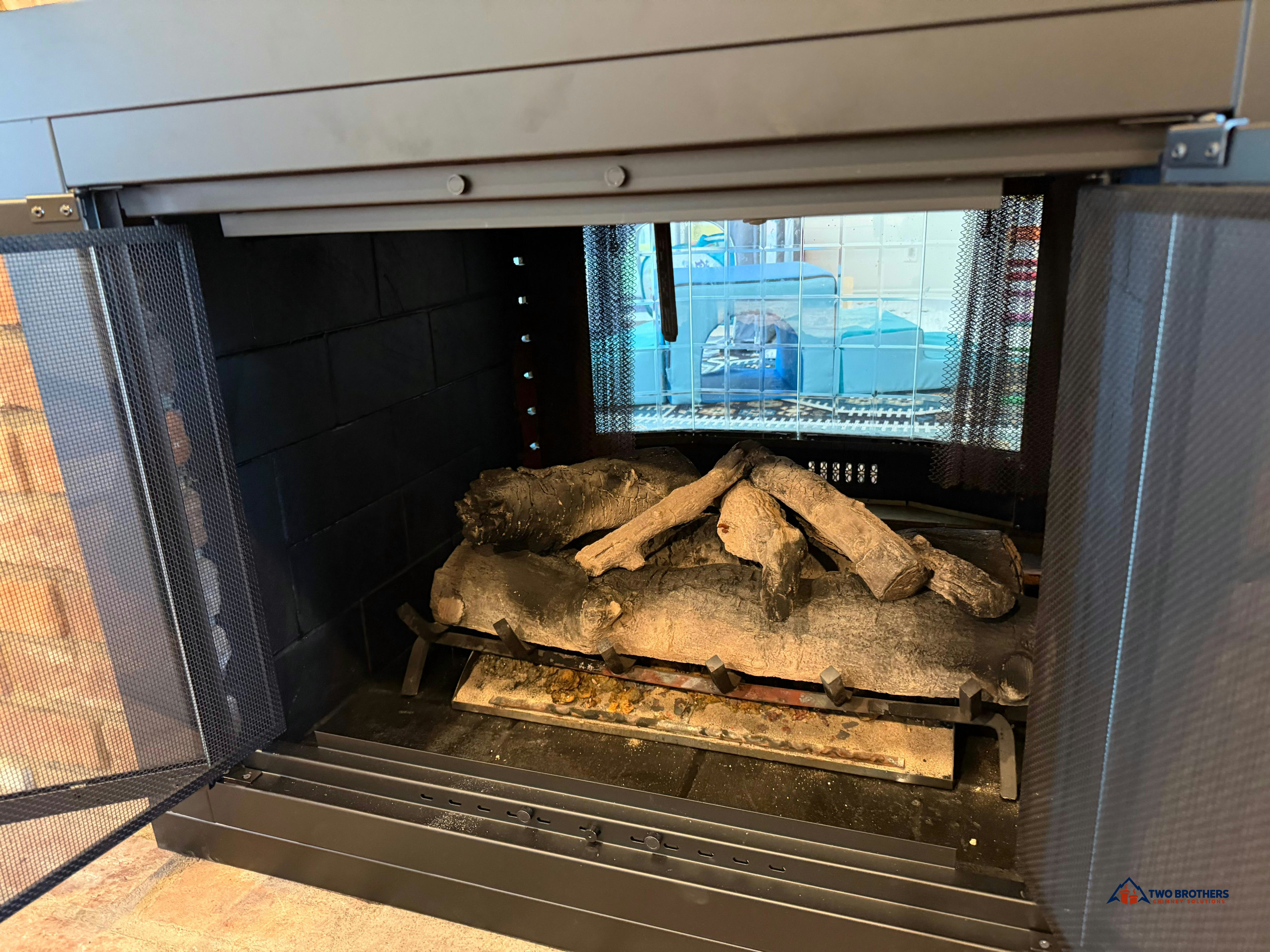 Unlit gas log set inside an open fireplace